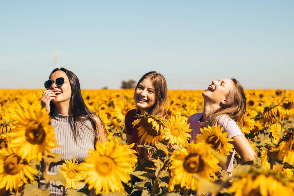 Girls smiling among sunflowers