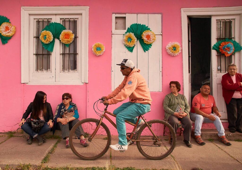 man cycling in front of a pink wall in chile
