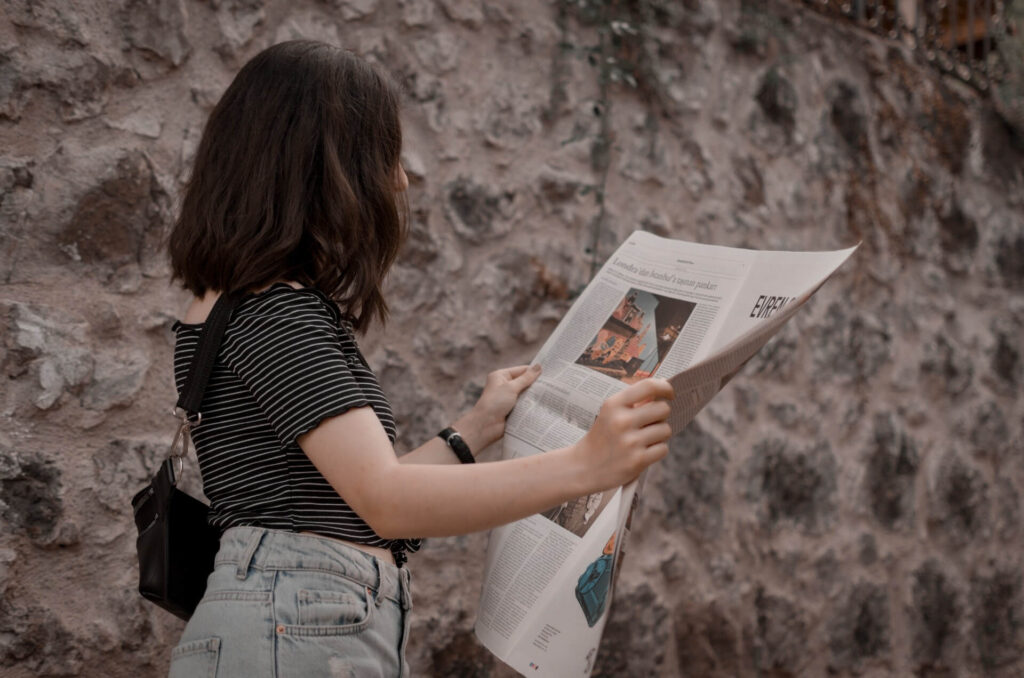 girl walking and reading the spanish newspaper
