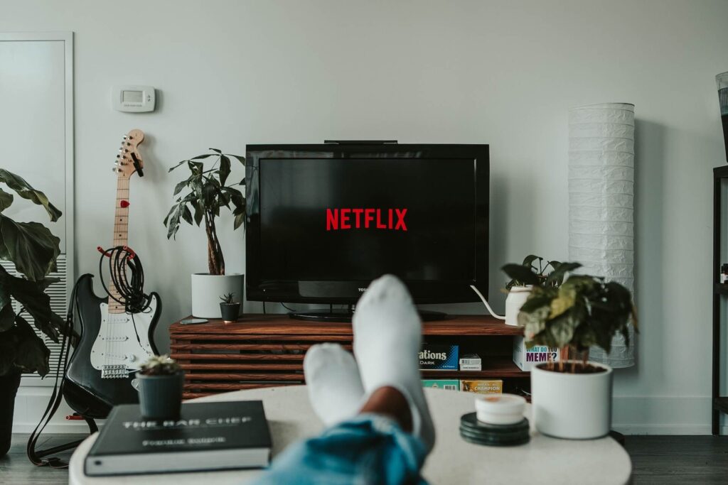 person relaxing in their lounge watching netflix in spanish