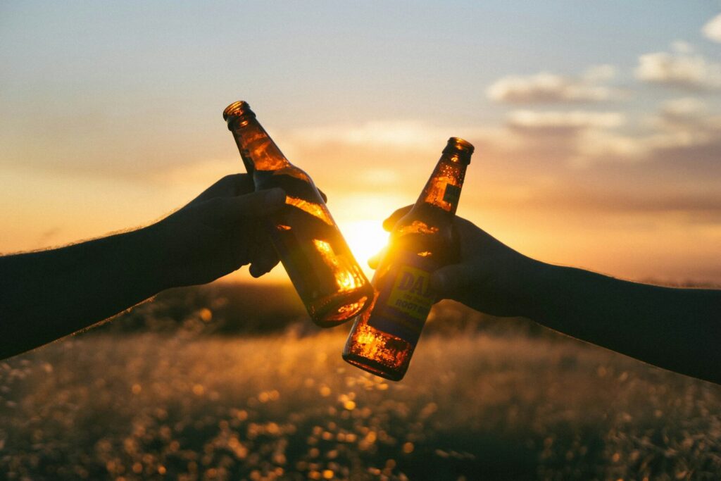 people cheersing with beers in the sunset